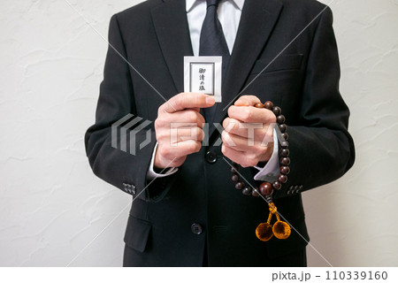数珠とお清めの塩を持った男性 110339160