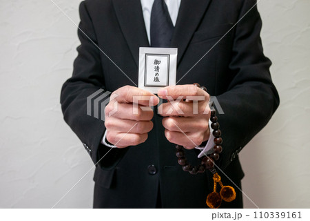 数珠とお清めの塩を持った男性 数珠とお清めの塩を持った男性 110339161