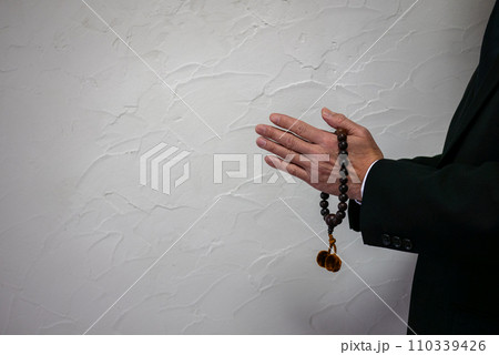 数珠を持っている男性の手元 110339426