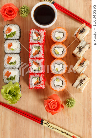 Japanese food. Different pieces of rolls on a wooden board. View from above Japanese food. Different pieces of rolls on a wooden board. View from above 110340595