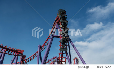 People excitement on red Roller Coaster against blue sky People excitement on red Roller Coaster against blue sky 110341522