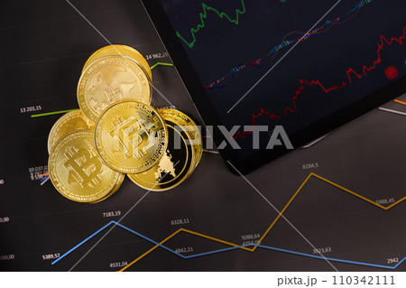 Crypto coins near digital tablet over graph Crypto coins near digital tablet over graph 110342111