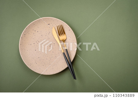 Empty round ceramic plate on a plain background, flatley with copy space 110343889