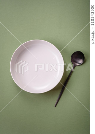Empty round ceramic plate on a plain background, flatley with copy space 110343900