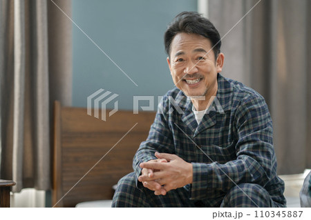 カメラ目線で笑顔のパジャマを着た中高年男性 110345887