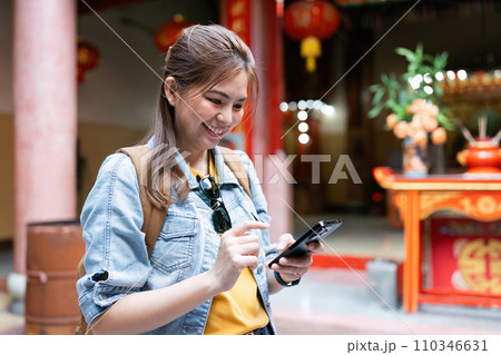 Young Asian woman backpack traveler using a mobile. Journey trip lifestyle. travel concept Young Asian woman backpack traveler using a mobile. Journey trip lifestyle. travel concept 110346631