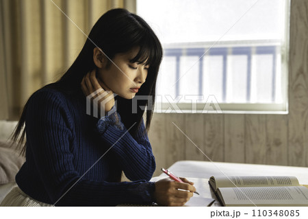 部屋で勉強する若い女性 110348085