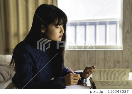 部屋で勉強する若い女性 110348087