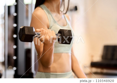 ダンベルアームカールで腕を鍛える女性 ダンベルアームカールで腕を鍛える女性 110348920