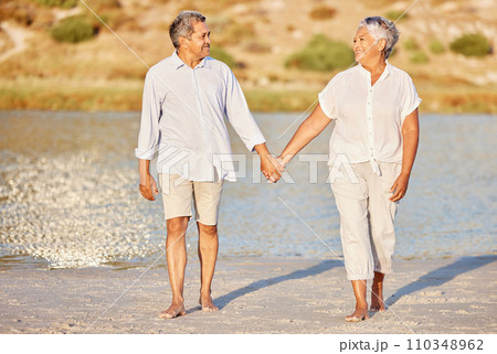 Love, walking and senior couple on a beach lake together for calm, relax and romantic ocean, water or sea date. Elderly happy people, man and woman smile while living pension and retirement lifestyle 110348962