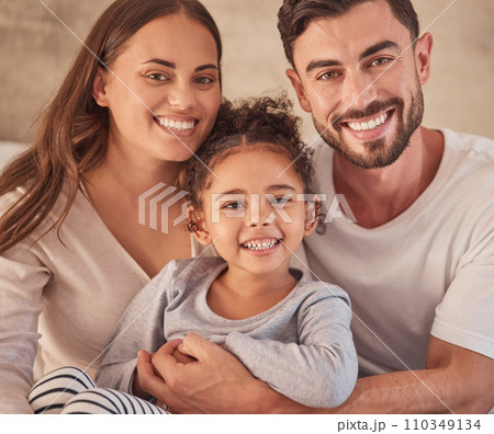 Happy family, girl and an interracial couple smiling and excited about spending quality time together. Portrait of parents, mother and father having fun with their adopted daughter at home 110349134