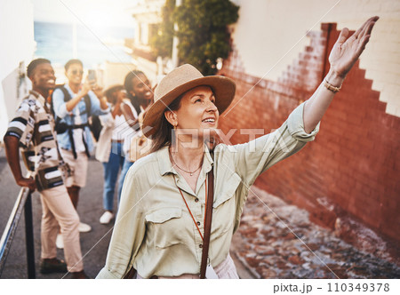Travel, education and a teacher with students on school field trip, on urban tour. Woman, city guide and group of happy tourists, pointing at local architecture and learning on international holiday. 110349378