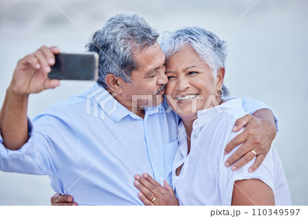 Love, senior couple taking phone selfie and smile, happy together and kiss for picture or video. Man and woman living retirement lifestyle take photograph with digital smartphone on romantic date 110349597
