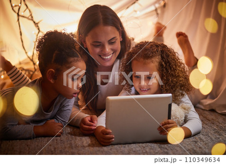 Home tent mother and kids on tablet watch movie or online children entertainment movies at night at house. Happy smile mom or woman and young girl youth family watching or playing fun internet games 110349634
