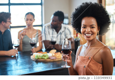 Portrait of a woman at a cheese and wine event with diverse friends at a modern restaurant. Happy girl having fun and holding a luxury glass of an alcohol for a toast at the table of a formal party. Portrait of a woman at a cheese and wine event with diverse friends at a modern restaurant. Happy girl having fun and holding a luxury glass of an alcohol for a toast at the table of a formal party. 110349931