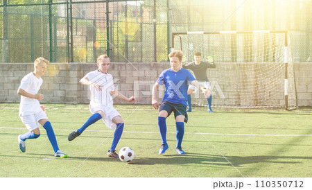 Football soccer players with ball. Footballers kicking football match on the pitch Football soccer players with ball. Footballers kicking football match on the pitch 110350712