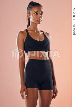 Healthy, fit and female fitness model in workout or sportswear while standing in a studio. Beautiful, sporty and active slim young woman with a wellness, health and athletic lifestyle. 110350755