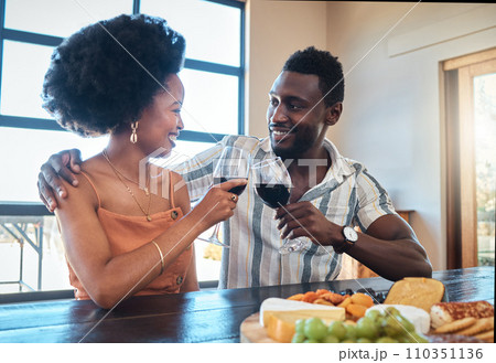 Celebration, love and black couple toasting with wine on a romantic date indoors, bonding and flirting. Lovers happy, in love and carefree, celebrating their anniversary and sharing intimate moment 110351136