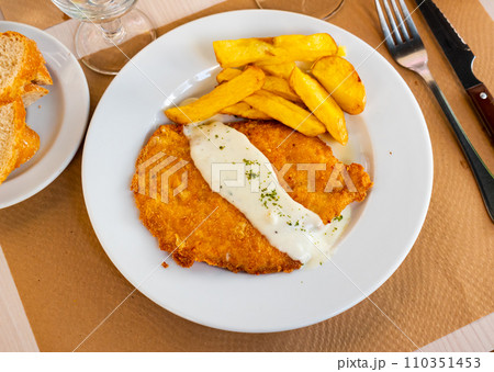 Chicken escalope with roquefort sauce, served with crispy french fries Chicken escalope with roquefort sauce, served with crispy french fries 110351453