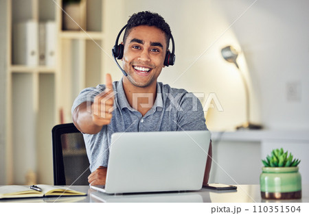 Thumbs up by call center, looking pleased and showing support with hand gesture while working on a laptop in an office alone at work. Portrait of an excited customer service agent expressing thanks 110351504