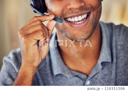 . Happy, smiling and friendly call center agent wearing headset while working in an office. Closeup smile of a confident man consulting and operating helpdesk for customer sales and service support. 110351506