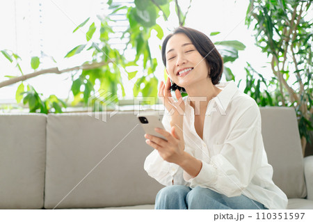 リビングでスマホを使う女性 リビングでスマホを使う女性 110351597