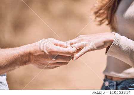 Engagement, proposal and romance while putting a ring on the finger of a woman saying yes to marriage outside. Closeup hands of a young couple telling you to save the date for their wedding day 110352214