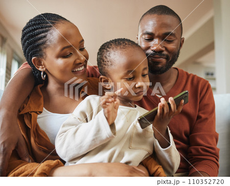 Happy, bonding and family time with a black family on a video call. Young parents being affectionate with their baby while streaming and watching something on a phone, enjoying time with their son Happy, bonding and family time with a black family on a video call. Young parents being affectionate with their baby while streaming and watching something on a phone, enjoying time with their son 110352720