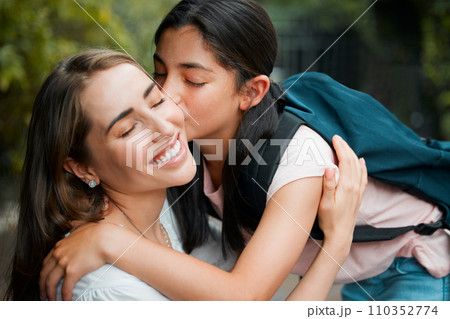 Happy, smiling and young daughter kissing her mother, hugging and greeting before school in the morning. Loving, caring and cheerful parent embracing, holding and giving goodbye hug to little girl 110352774