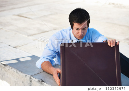 Suitcase, rooftop and businessman on a building in the city searching or looking for work bag. Corporate career, balcony and professional male lawyer with briefcase for legal documents in urban town. Suitcase, rooftop and businessman on a building in the city searching or looking for work bag. Corporate career, balcony and professional male lawyer with briefcase for legal documents in urban town. 110352973