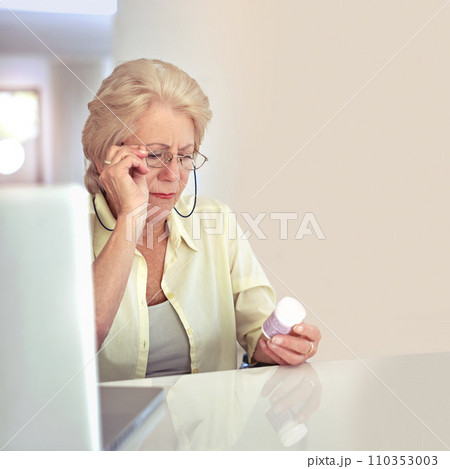 Making sure shes taking the right dose. a senior woman checking her medication at home. 110353003