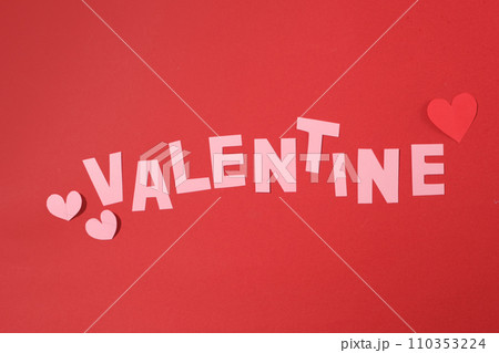 The word VALENTINE and heart shapes are cut from paper, arranged on a red background. Valentine theme with copy space and top view. Decorative space. The word VALENTINE and heart shapes are cut from paper, arranged on a red background. Valentine theme with copy space and top view. Decorative space. 110353224