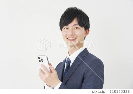 スマートフォンを使うビジネスマン　白背景　カメラ目線 110353328