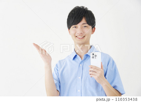 スマートフォンを持って手のひらで左側を指す男性 白背景 スマートフォンを持って手のひらで左側を指す男性 白背景 110353438