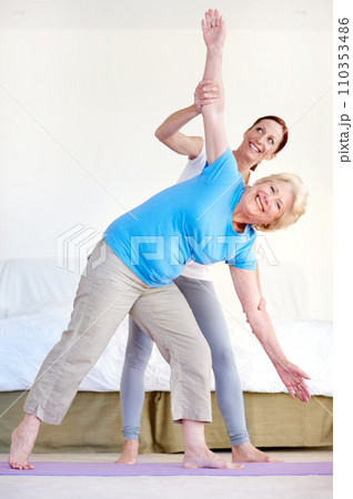 Senior health and exercise. Full-length portrait of an elderly woman doing stretches with her fitness trainer. Senior health and exercise. Full-length portrait of an elderly woman doing stretches with her fitness trainer. 110353486