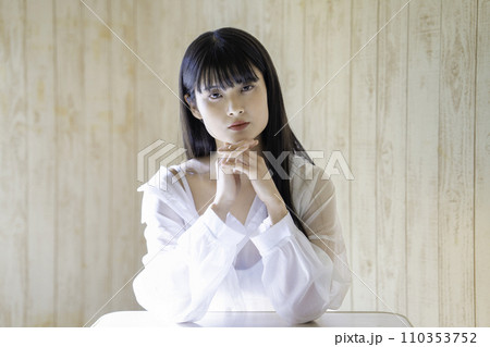 ラフな服装でくつろぐフェミニンな雰囲気の若い女性 110353752