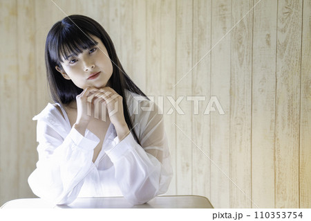 ラフな服装でくつろぐフェミニンな雰囲気の若い女性 ラフな服装でくつろぐフェミニンな雰囲気の若い女性 110353754