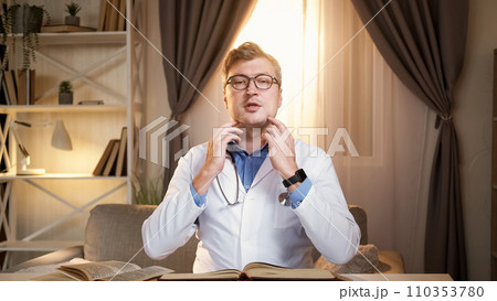 Medical checkup. Doctor instructions. Clinic blog. Smart man showing self examination technique palpating neck throat zone under ears for video content in modern hospital interior. 110353780