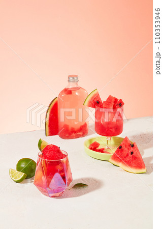 Juice and fresh watermelon pieces stand out against the pastel background. The two types of vitamins A and C found in watermelon play an extremely important role in skin and hair health. 110353946