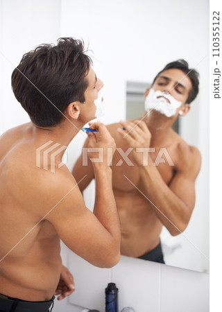 Man, shaving cream and blade in mirror for hair removal in bathroom, beauty and wellness. Male person, skincare and cosmetics or cleaning in morning routine, grooming and razor in reflection at home 110355122