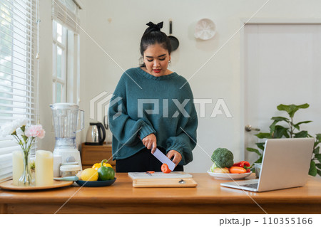 Fat woman cooking in kitchen and chopping fresh vegetables on chopping board. Learn to make salads and healthy food from online. health care concept Eat healthy food to lose weight Fat woman cooking in kitchen and chopping fresh vegetables on chopping board. Learn to make salads and healthy food from online. health care concept Eat healthy food to lose weight 110355166
