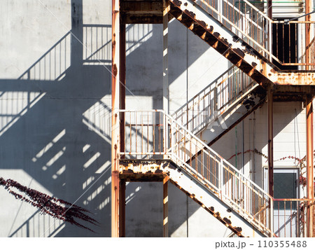 Old fire escape staircase installed on building wall. Old fire escape staircase installed on building wall. 110355488