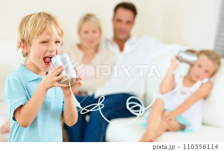 Home, family and children with tin can, game and fun in a living room, love and bonding together. Parents on a sofa, mother and father with kids, apartment or communication with smile, playing or joy Home, family and children with tin can, game and fun in a living room, love and bonding together. Parents on a sofa, mother and father with kids, apartment or communication with smile, playing or joy 110356114