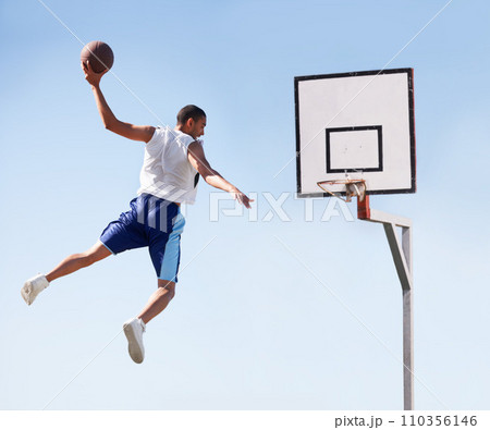 Man, basketball and dunk jump on outdoor court for scoring point, game challenge or athlete. Male person, hand and hoop strong for exercise fun or fitness training in summer, player for winner match 110356146