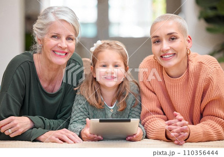 Little girls rule the world. Portrait of a mature woman bonding with her daughter and granddaughter while using a digital tablet. 110356444