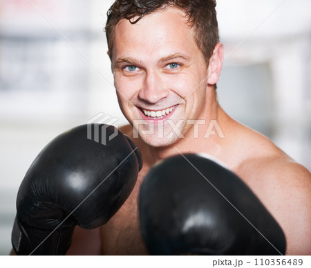 Boxing, gloves and portrait of happy man with fitness, power and training for challenge in gym. Strong body, muscle and smile, boxer or athlete with fist up, face and confidence in competition fight. Boxing, gloves and portrait of happy man with fitness, power and training for challenge in gym. Strong body, muscle and smile, boxer or athlete with fist up, face and confidence in competition fight. 110356489