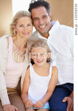 Delighted family of three. Two delighted parents sitting with their adorable daughter. 110356530