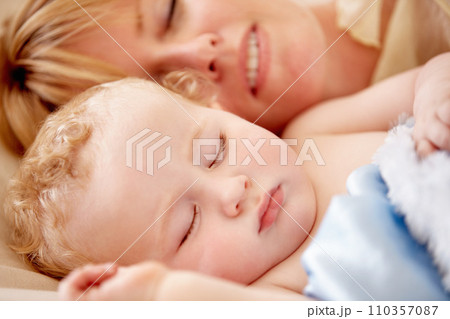 Sleeping, mom and calm baby in bed together with peace, happiness and love for infant in morning nap. Mother, cuddle and sleep with child in closeup and rest with a smile in bedroom or family home Sleeping, mom and calm baby in bed together with peace, happiness and love for infant in morning nap. Mother, cuddle and sleep with child in closeup and rest with a smile in bedroom or family home 110357087