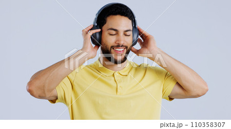 Man, music and headphones in studio for freedom, audio subscription and streaming multimedia playlist on white background. Happy indian model listening to peaceful podcast, hearing sound and radio 110358307