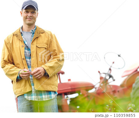 The happiest life is a simple one. Portrait of a farmer standing in a field with his tractor parked behind him - Copyspace. The happiest life is a simple one. Portrait of a farmer standing in a field with his tractor parked behind him - Copyspace. 110359855